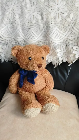 Oso de peluche marrón con lazo azul