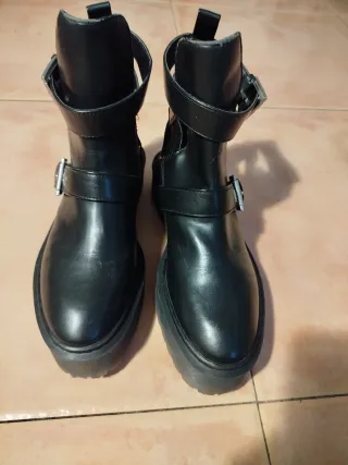 Botas negras con hebillas y cortes
