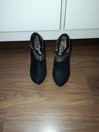 Botines de tacón fino negros con adornos dorados