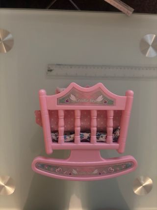 Cuna rosa para muñeco con ropa de cama