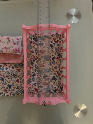 Cuna rosa para muñeco con ropa de cama