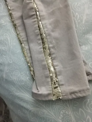Pantalones vaqueros beige con detalles dorados