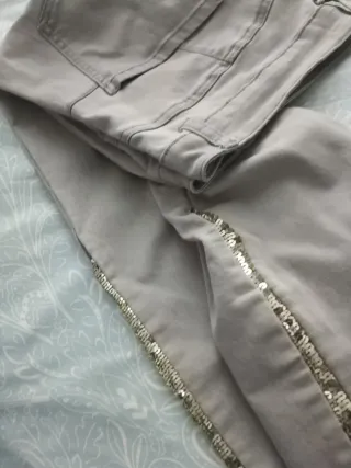 Pantalones vaqueros beige con detalles dorados