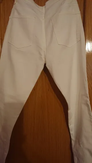 Pantalones blancos y camisa azul ajustada