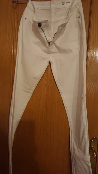 Pantalones blancos y camisa azul ajustada