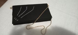 Bolso de mano negro con cadena dorada