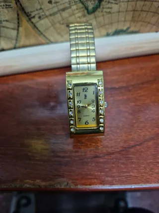 Reloj dorado con detalles de cristal