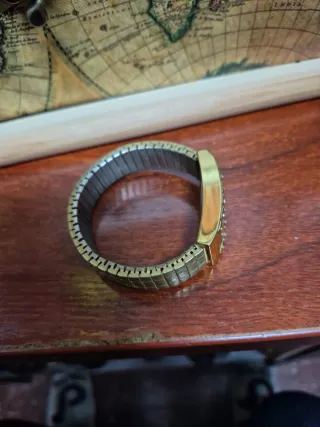 Reloj dorado con detalles de cristal