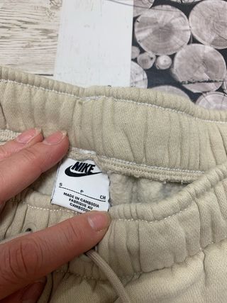 Calças Nike bege com swoosh branco