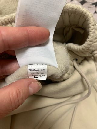 Calças Nike bege com swoosh branco