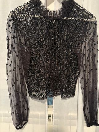 Blusa negra con pedrería y transparencias