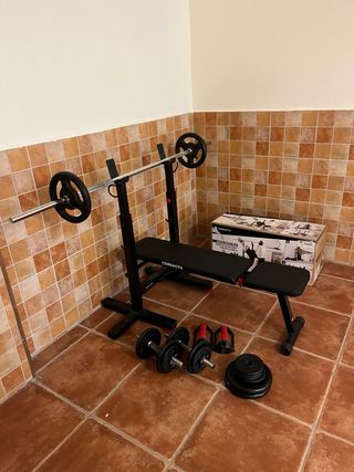 Banco musculación con barra y pesas