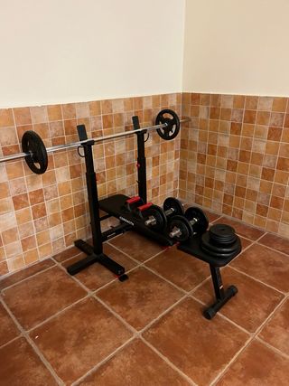 Banco musculación con barra y pesas