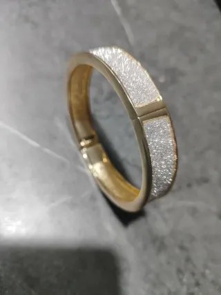 Pulsera dorada con detalles plateados