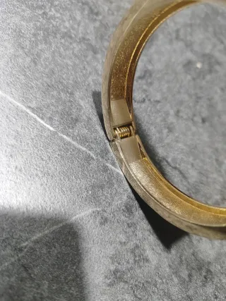 Pulsera dorada con detalles plateados