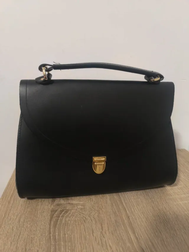 Bolso negro con asa y cierre dorado