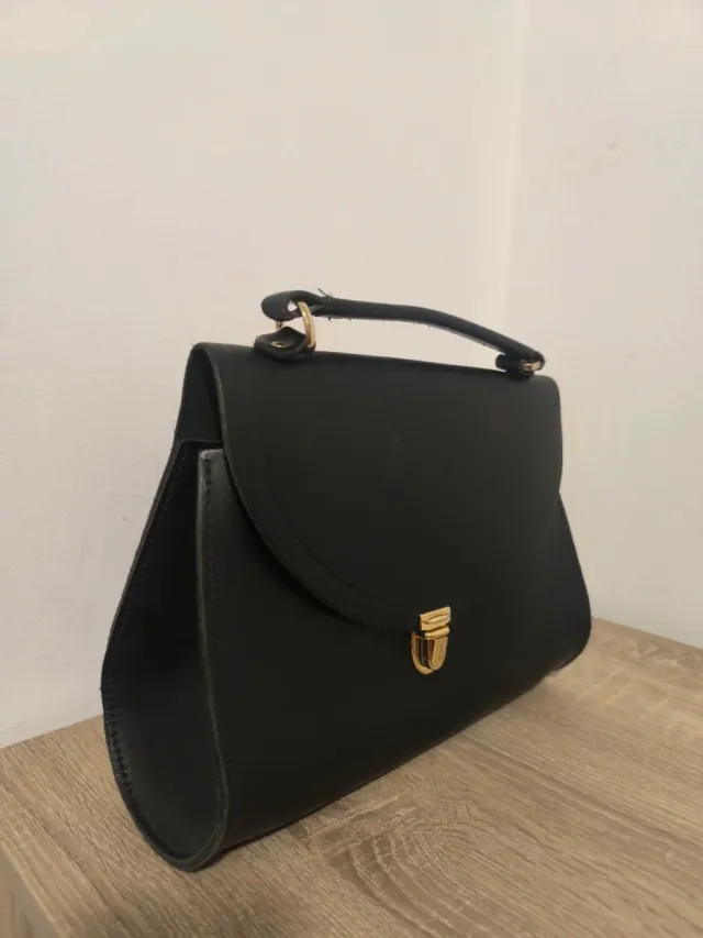 Bolso negro con asa y cierre dorado