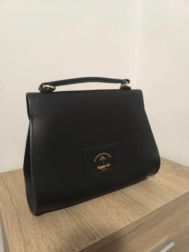 Bolso negro con asa y cierre dorado