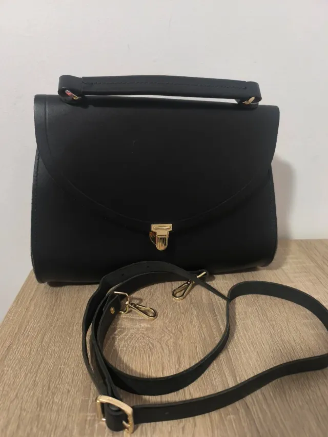 Bolso negro con asa y cierre dorado