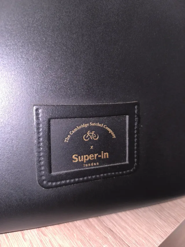 Bolso negro con asa y cierre dorado