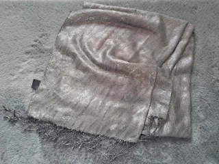 Sciarpa elegante in tessuto luminoso con frange