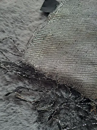 Sciarpa elegante in tessuto luminoso con frange