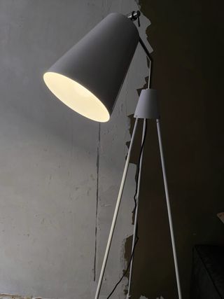 Lámpara de pie trípode gris/blanca.