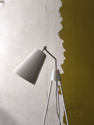 Lámpara de pie trípode gris/blanca.