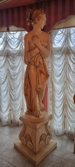 Estatua de diosa de piedra beige y dorada