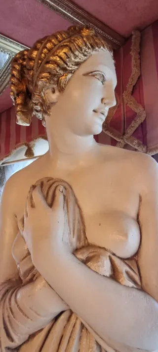 Estatua de diosa de piedra beige y dorada