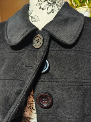 Abrigo negro con botones.