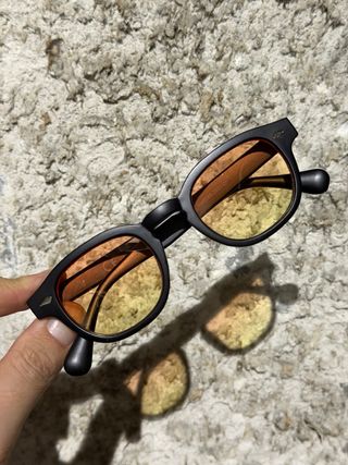 Occhiali da sole neri con lenti arancioni