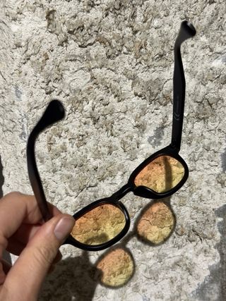 Occhiali da sole neri con lenti arancioni