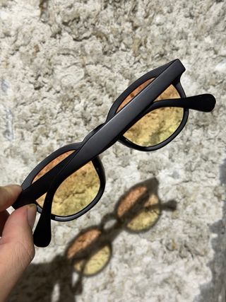 Occhiali da sole neri con lenti arancioni