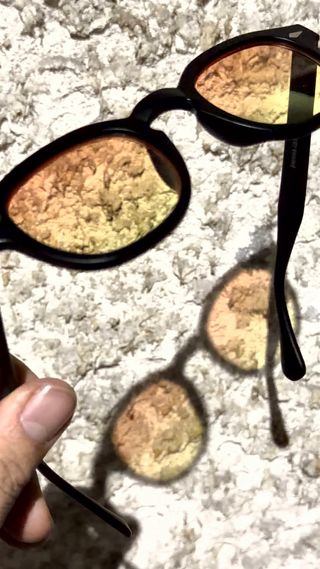 Occhiali da sole neri con lenti arancioni