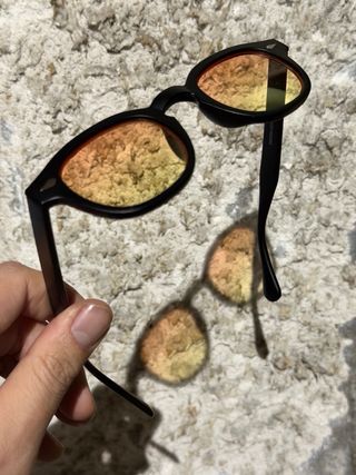 Occhiali da sole neri con lenti arancioni