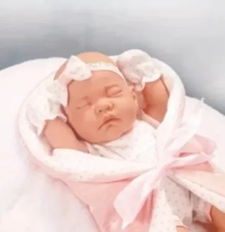 Bebé realista con vestido y diadema