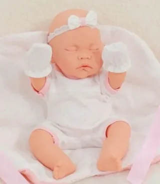 Bebé realista con vestido y diadema