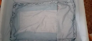 Minicuna azul con estructura de madera y ruedas