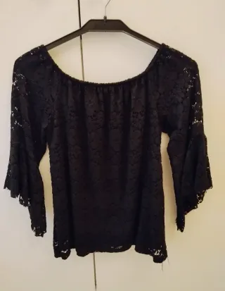 Blusa de encaje negro con manga acampanada.