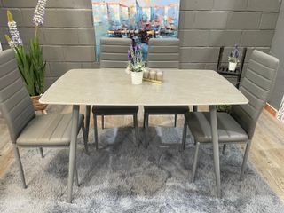Mesa de comedor gris con 4 sillas acolchadas