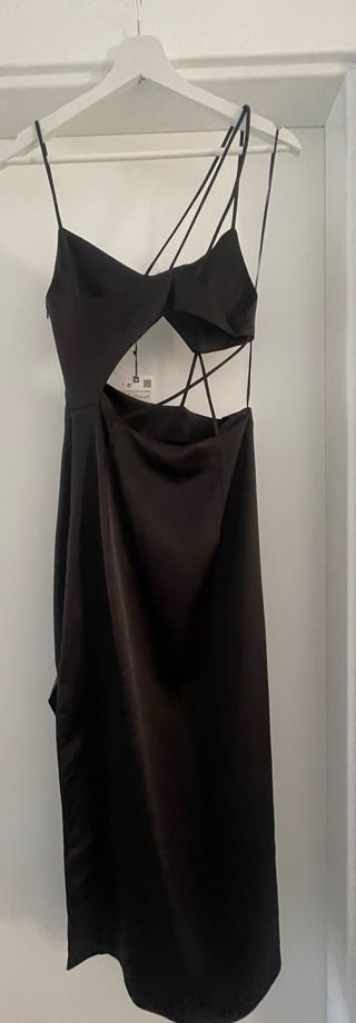 Vestido negro satinado con abertura lateral.