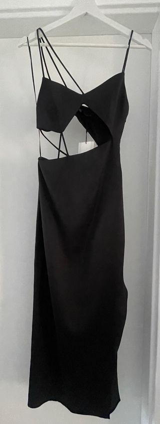 Vestido negro satinado con abertura lateral.