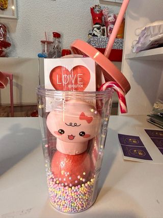 Vaso con maquillaje y accesorios