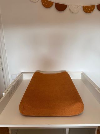 Cambiador de bebé blanco con cojín naranja