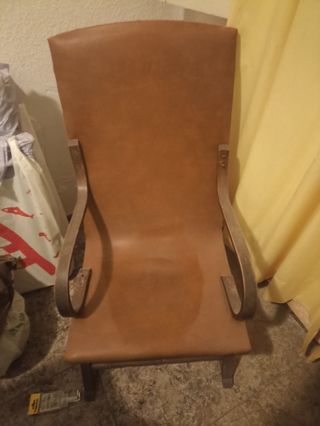 Vecchia sedia a dondolo in pelle e legno