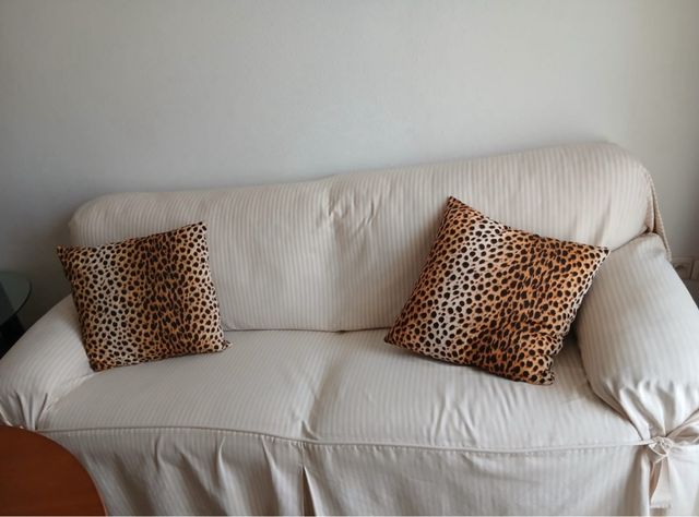 Sofá beige con fundas y cojines