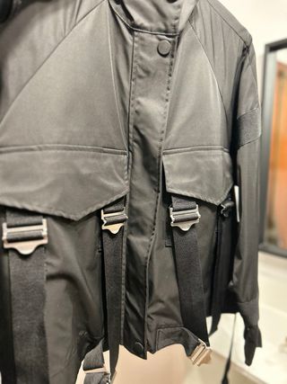 Chaqueta técnica negra con correas y hebillas