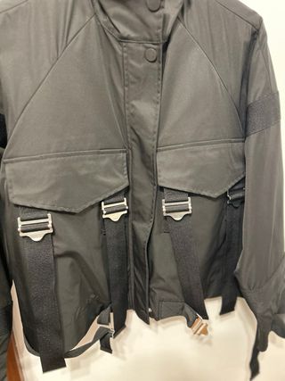 Chaqueta técnica negra con correas y hebillas