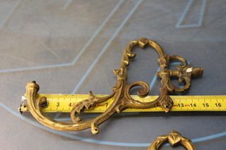 Tres apliques, tiradores, asas o adornos de bronce o latón.